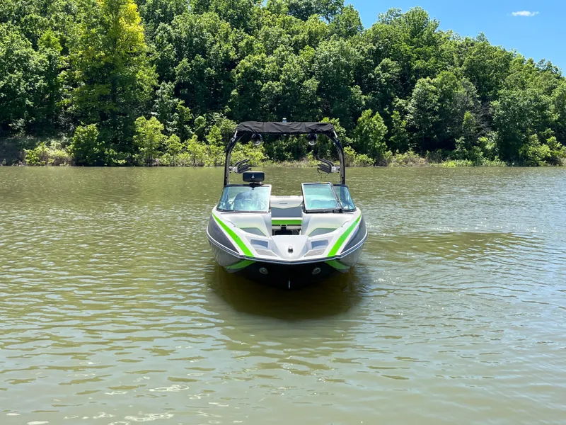 Slide: The Image of 2016 Moomba Mojo boat on a calm lake with lush green forest background. - 12