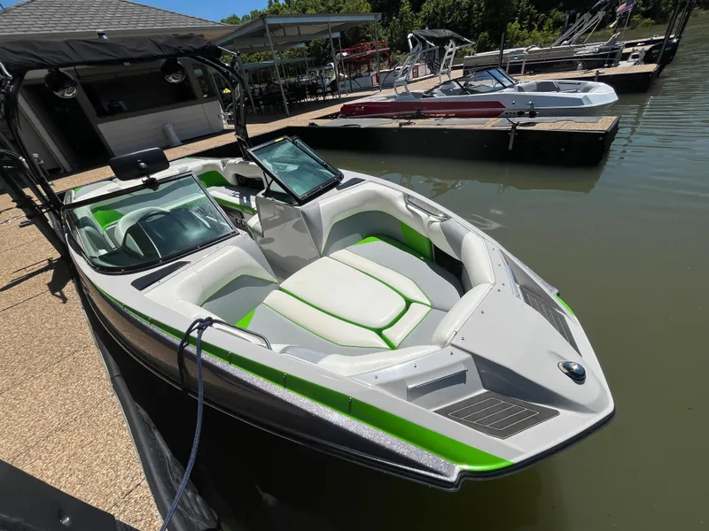 Slide: The Image of 2016 Moomba Mojo boat docked, featuring sleek design and green-accented interior. - 26