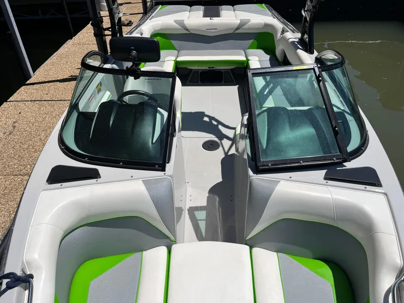 Slide: The Image of 2016 Moomba Mojo boat interior with green and white seating, open windshield, and sleek design. - 29