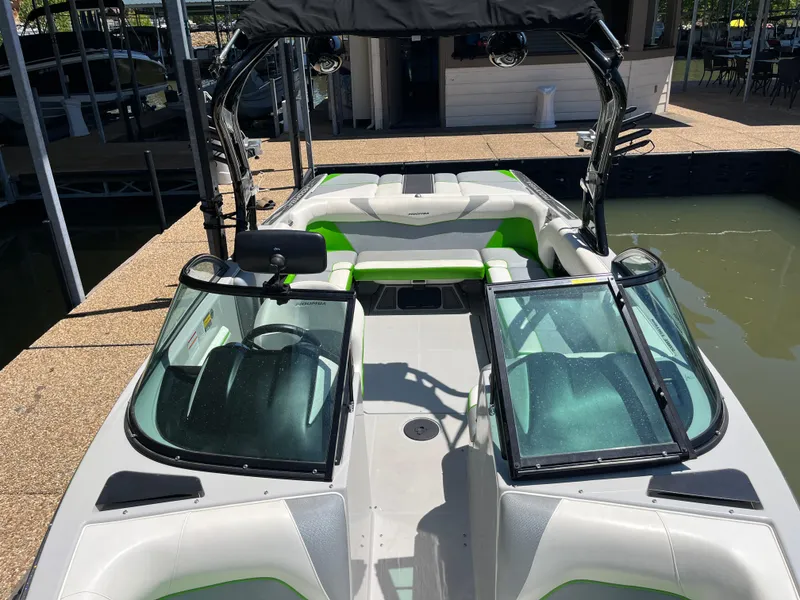 Slide: The Image of 2016 Moomba Mojo boat with green accents, docked in a marina. - 30