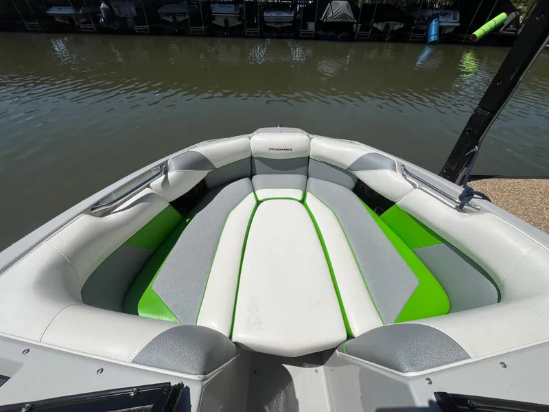 Slide: The Image of 2016 Moomba Mojo boat interior with green and gray seating by the water. - 33