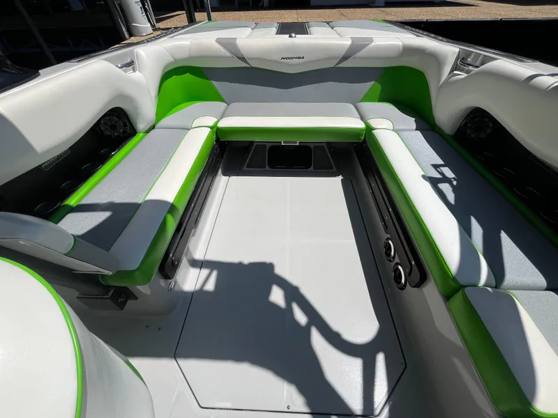 Slide: The Image of 2016 Moomba Mojo boat interior with green and gray seating, spacious layout. - 34