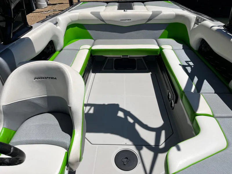 Slide: The Image of 2016 Moomba Mojo boat interior with green and gray seating, spacious layout. - 35