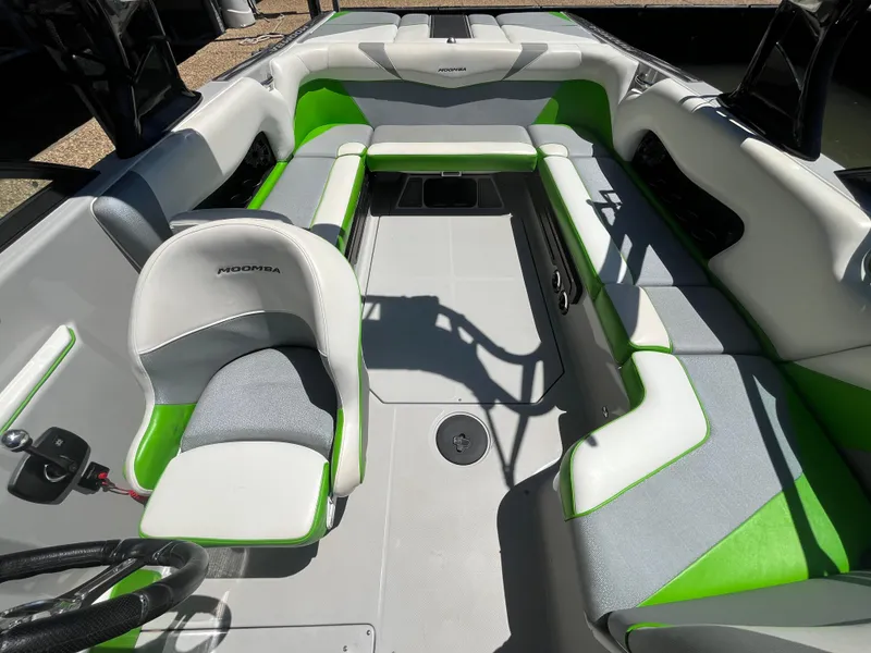 Slide: The Image of 2016 Moomba Mojo boat interior with green and gray seating, spacious layout. - 36