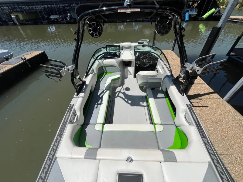 Slide: The Image of 2016 Moomba Mojo boat with green accents docked at a marina. - 38