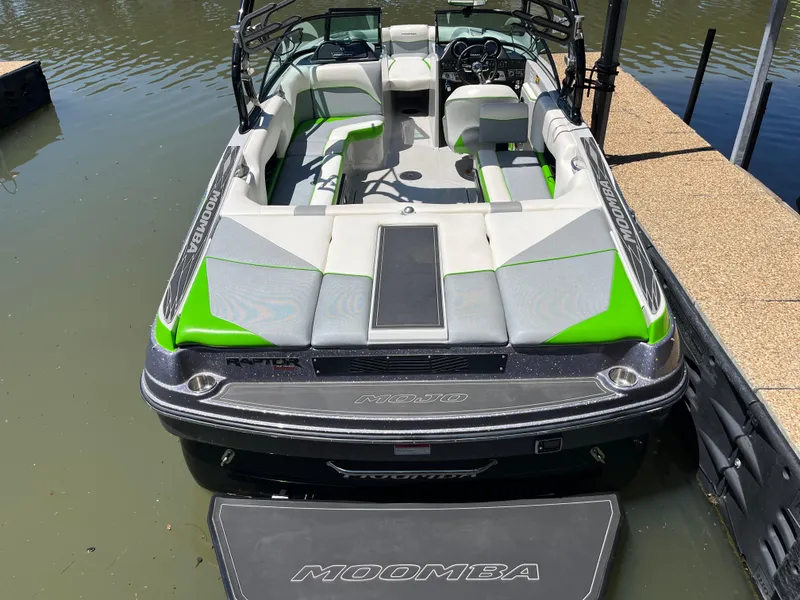 Slide: The Image of 2016 Moomba Mojo boat with green and gray interior docked on calm water. - 40