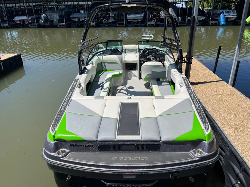 Slide: The Image of 2016 Moomba Mojo boat with green and gray interior, docked on calm water. - 41