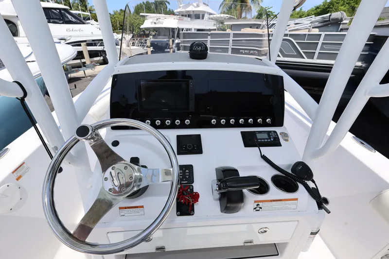 Slide: The Image of 2020 Sportsman Heritage 211 Center Console boat dashboard with steering wheel and controls. - 27