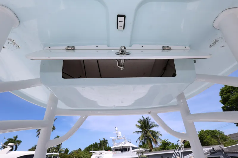 Slide: The Image of 2020 Sportsman Heritage 211 Center Console boat with open storage compartment, tropical background. - 29
