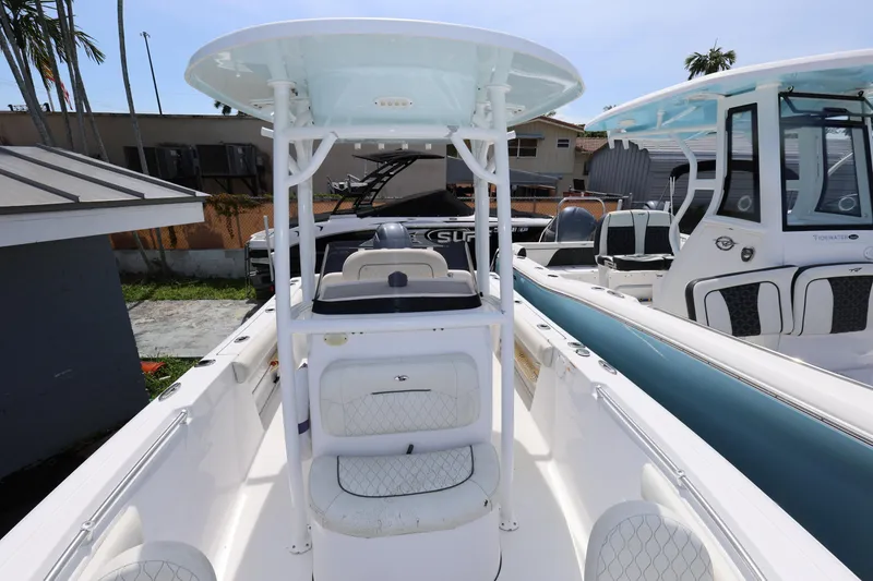 Slide: The Image of 2020 Sportsman Heritage 211 Center Console boat, white interior, docked alongside similar vessels. - 32