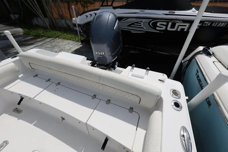 Slide: The Image of 2020 Sportsman Heritage 211 Center Console boat with 150 HP engine, docked beside another vessel. - 37
