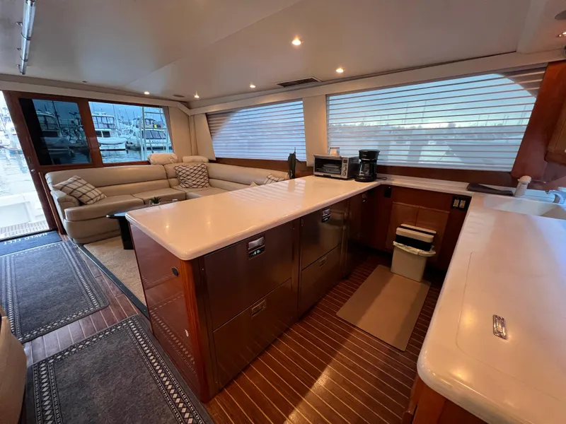 Slide: The Image of Luxurious interior of a 2000 Viking 58 Enclosed Bridge yacht with modern kitchen and seating area. - 11