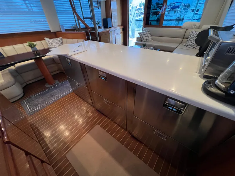Slide: The Image of Luxurious interior of 2000 Viking 58 Enclosed Bridge yacht with modern kitchen and seating area. - 18