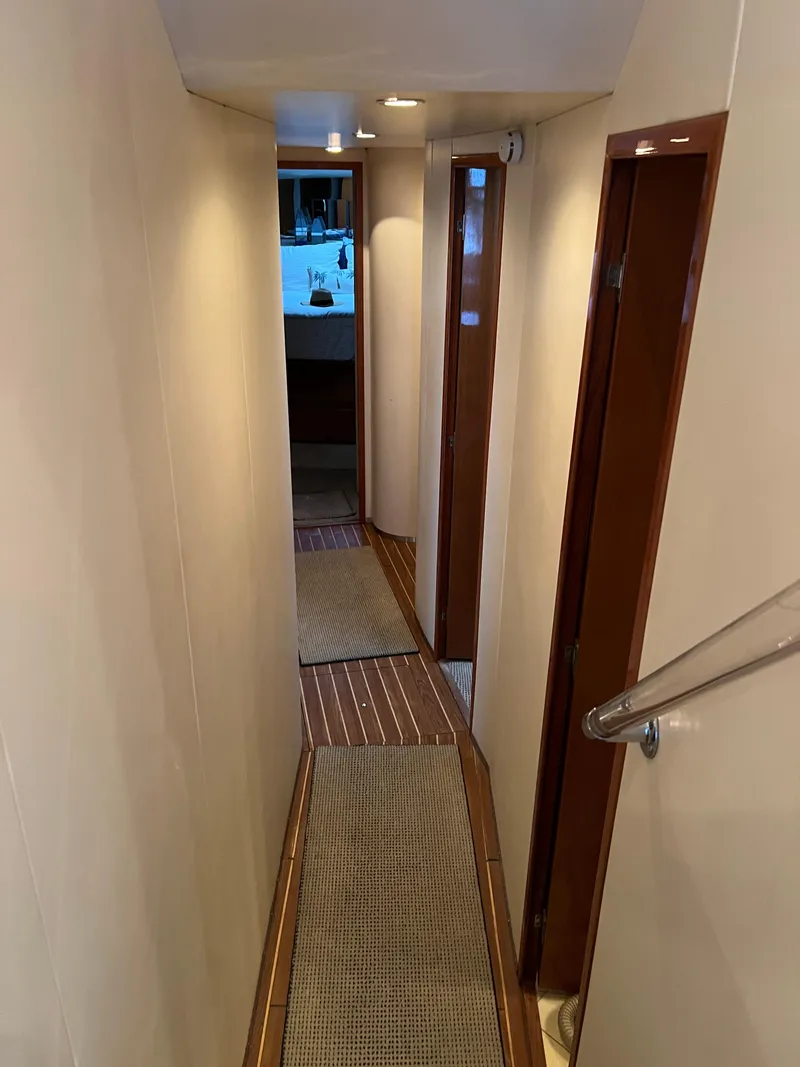 Slide: The Image of Narrow hallway inside 2000 Viking 58 Enclosed Bridge yacht with wooden accents. - 20