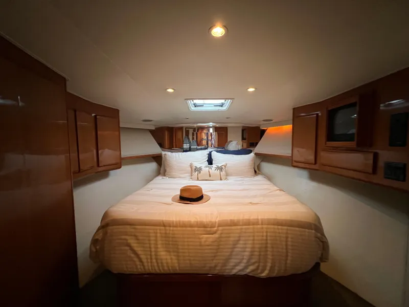 Slide: The Image of Luxurious bedroom interior of 2000 Viking 58 Enclosed Bridge yacht with cozy bed and hat. - 23