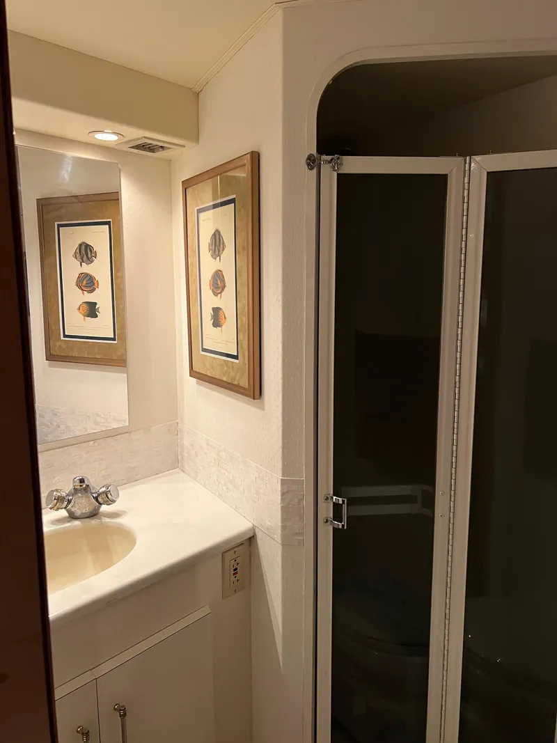 Slide: The Image of Bathroom interior of 2000 Viking 58 Enclosed Bridge yacht, featuring sink and shower. - 26