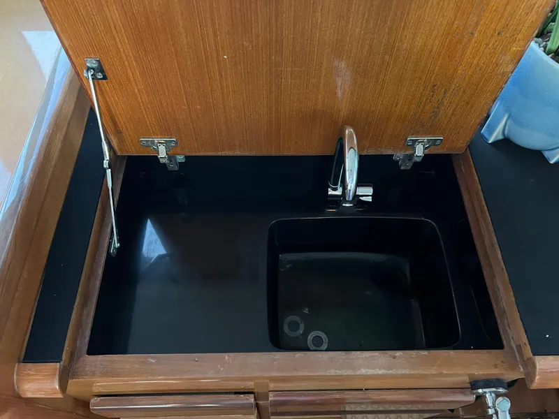 Slide: The Image of Wooden cabinet with a built-in sink and faucet on a 2000 Viking 58 Enclosed Bridge yacht. - 31