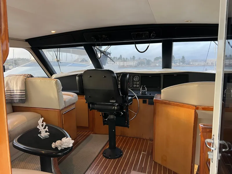Slide: The Image of 2000 Viking 58 Enclosed Bridge yacht interior with helm, seating, and wooden flooring. - 37
