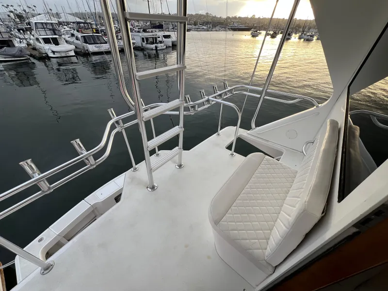 Slide: The Image of 2000 Viking 58 Enclosed Bridge yacht deck with seating, overlooking marina at sunset. - 40