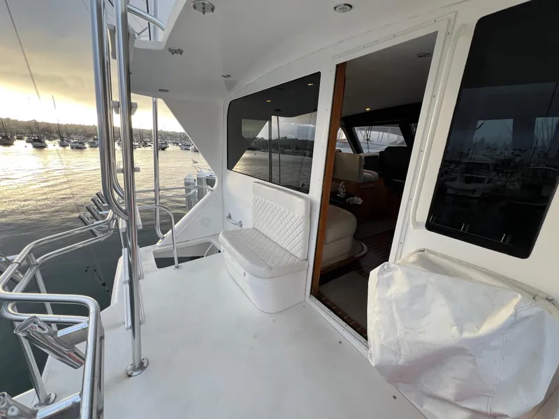 Slide: The Image of 2000 Viking 58 Enclosed Bridge yacht deck with seating, overlooking marina at sunset. - 41