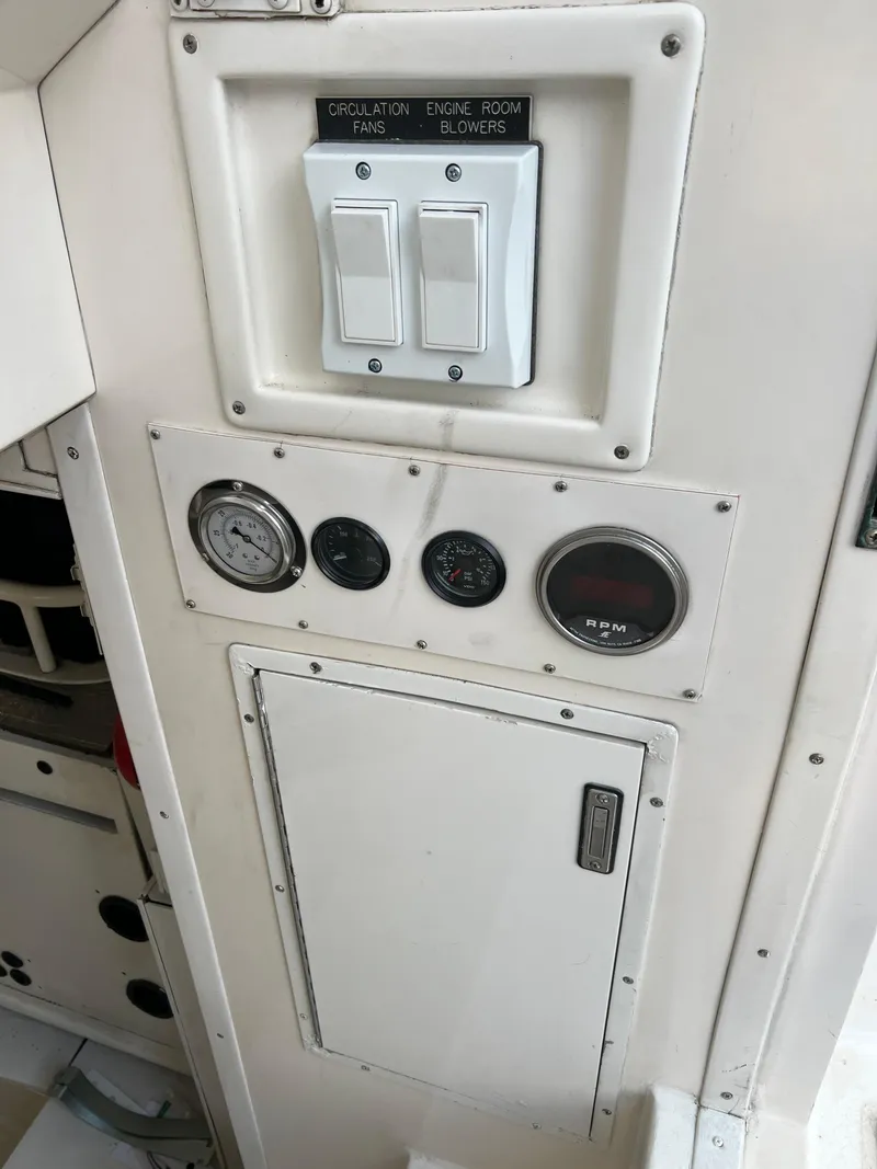 Slide: The Image of Control panel on a 2000 Viking 58 Enclosed Bridge yacht, featuring switches and gauges. - 49