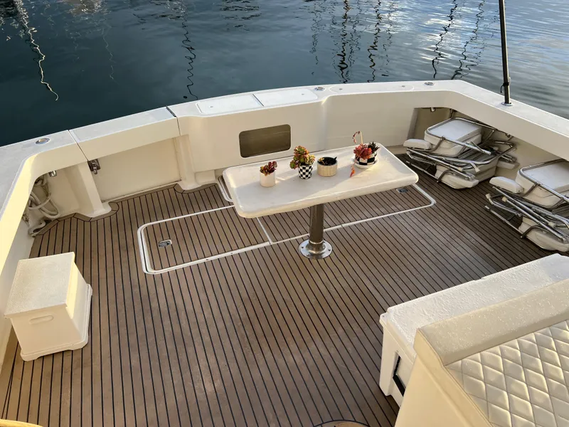 Slide: The Image of Luxurious deck of 2000 Viking 58 Enclosed Bridge yacht with elegant seating and table. - 6