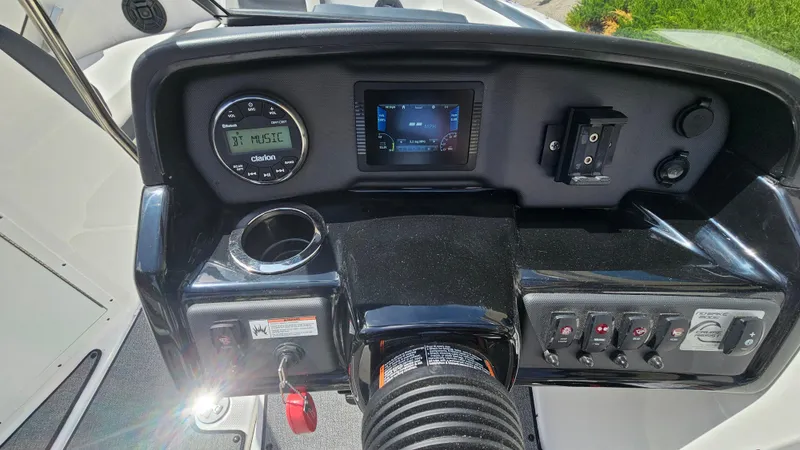 Slide: The Image of 2019 Yamaha AR195 boat dashboard with gauges, controls, and cup holder. - 13