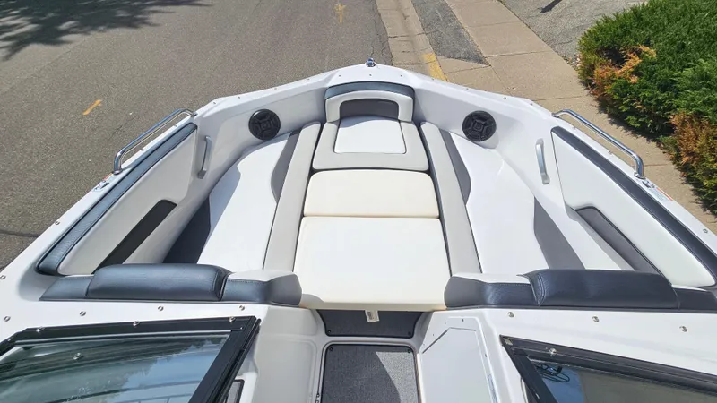 Slide: The Image of 2019 Yamaha Boats AR195 interior with white and black seating, docked on a sunny day. - 19