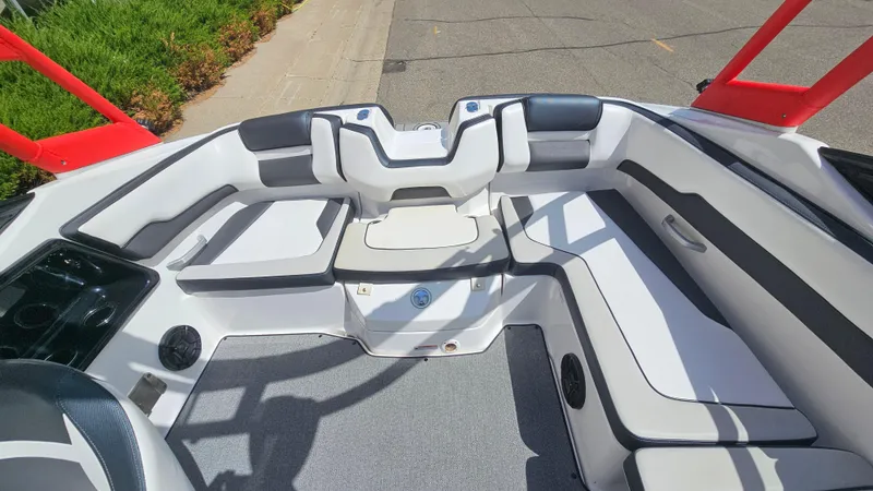 Slide: The Image of 2019 Yamaha Boats AR195 interior with white and gray seating, red accents, and spacious layout. - 9