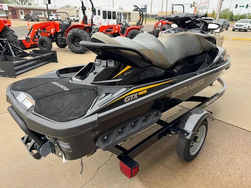 Slide: The Image of 2017 Sea-Doo GTX155 jet ski on trailer, displayed outdoors with tractors in background. - 8