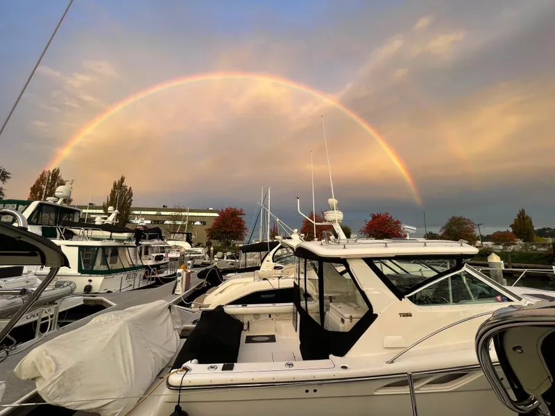 Slide: The Image of A 2003 Tiara Yachts 3500 Open docked under a vibrant rainbow at sunset. - 15