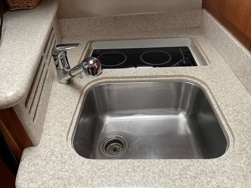 Slide: The Image of 2003 Tiara Yachts 3500 Open kitchen sink and stove in compact galley area. - 33