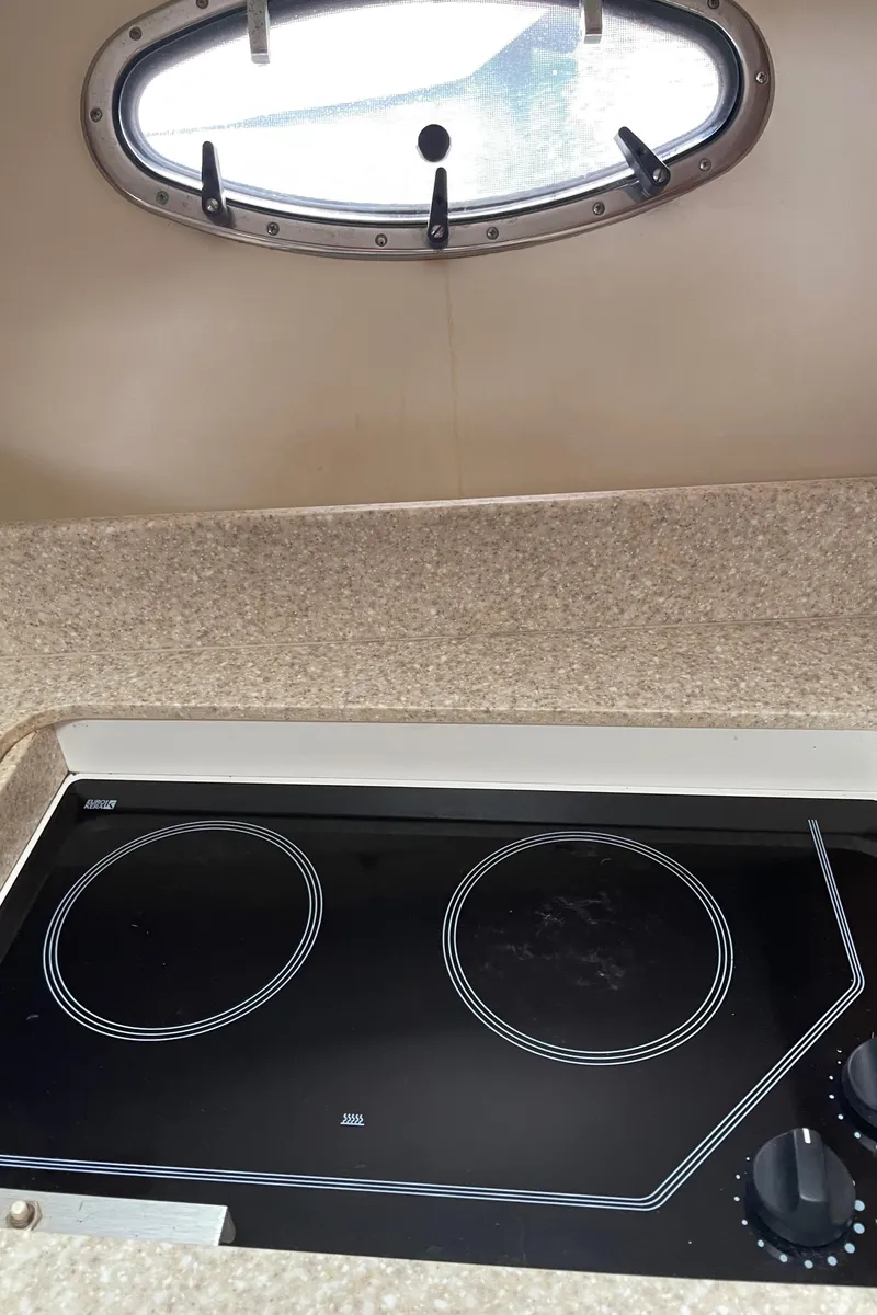 Slide: The Image of 2003 Tiara Yachts 3500 Open kitchen with electric stove and porthole window. - 48