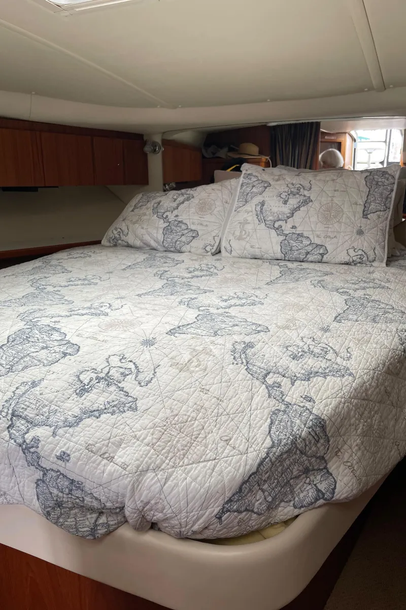 Slide: The Image of 2003 Tiara Yachts 3500 Open cabin with map-themed bedding. - 49