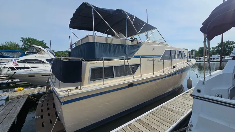 The Image of 1982 Chris-Craft 381 Catalina yacht docked at a marina, featuring a spacious deck and canopy. - 1