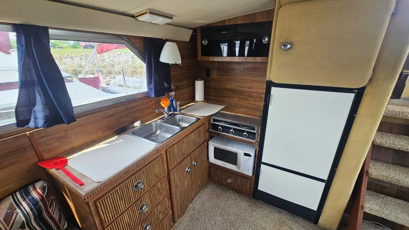 Slide: The Image of 1982 Chris-Craft 381 Catalina kitchen with wood cabinets, sink, stove, and refrigerator. - 10