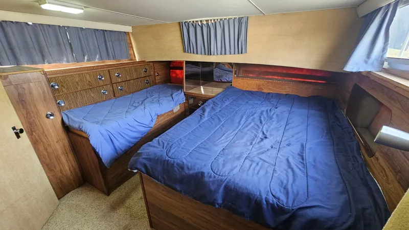 Slide: The Image of 1982 Chris-Craft 381 Catalina cabin with twin beds, blue bedding, and wood paneling. - 15