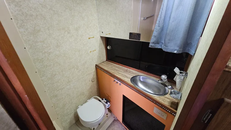 Slide: The Image of 1982 Chris-Craft 381 Catalina bathroom with sink, toilet, and curtain. - 18