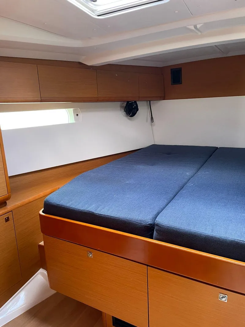 Slide: The Image of Interior cabin of 2017 Jeanneau Sun Odyssey 479 with wooden finish and blue bedding. - 16