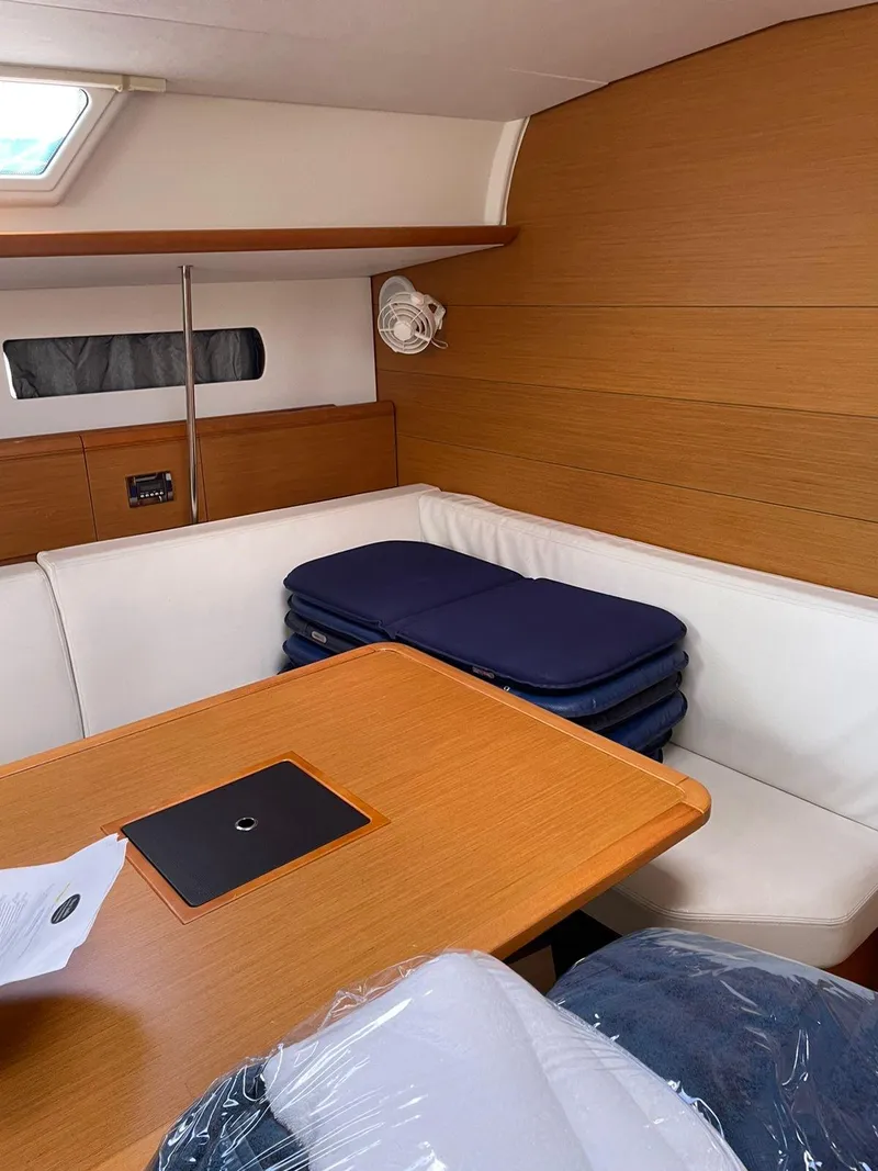 Slide: The Image of Interior of 2017 Jeanneau Sun Odyssey 479 sailboat with wooden table and white seating. - 21