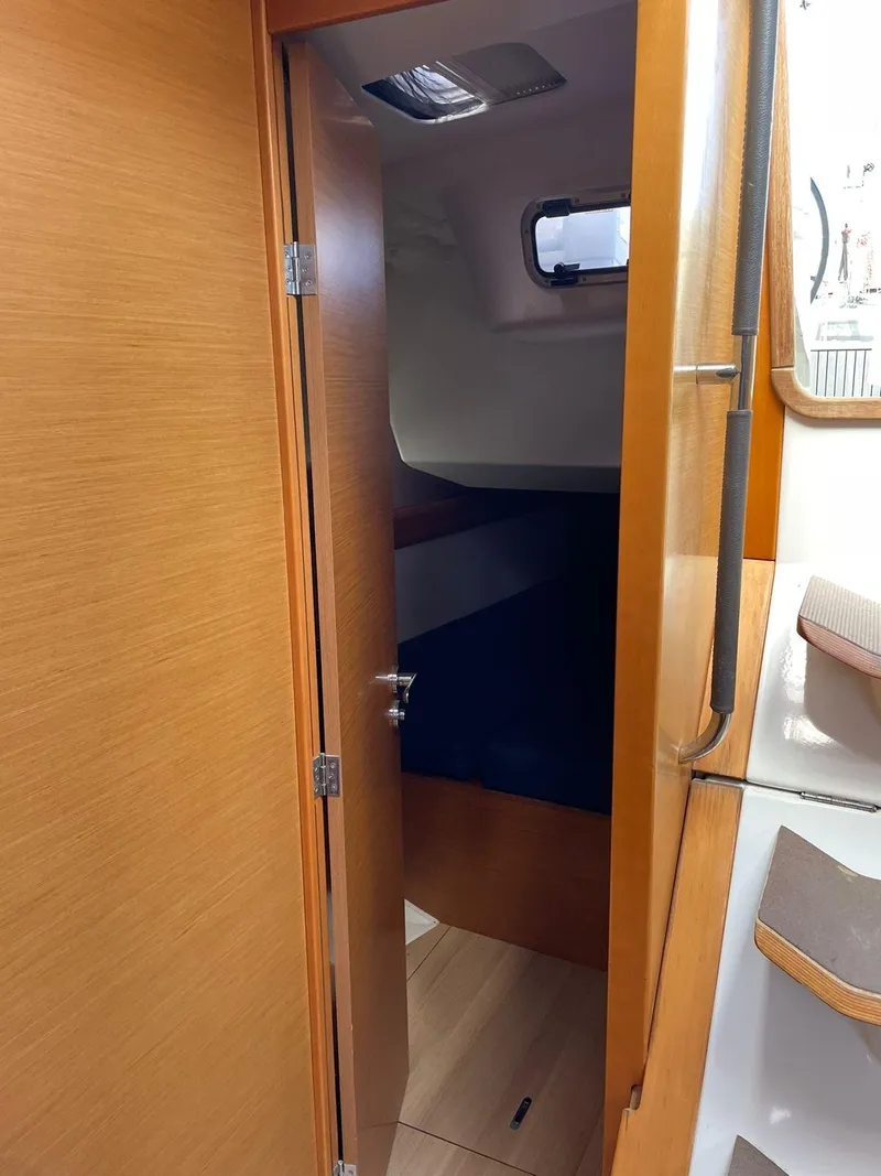 Slide: The Image of Interior cabin of 2017 Jeanneau Sun Odyssey 479 sailboat, featuring wooden door and cozy sleeping area. - 23