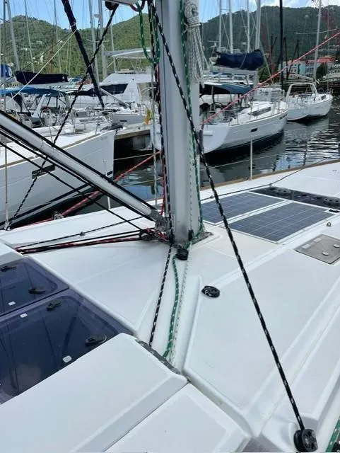 Slide: The Image of 2017 Jeanneau Sun Odyssey 479 sailboat docked in a marina, showcasing deck and rigging. - 43
