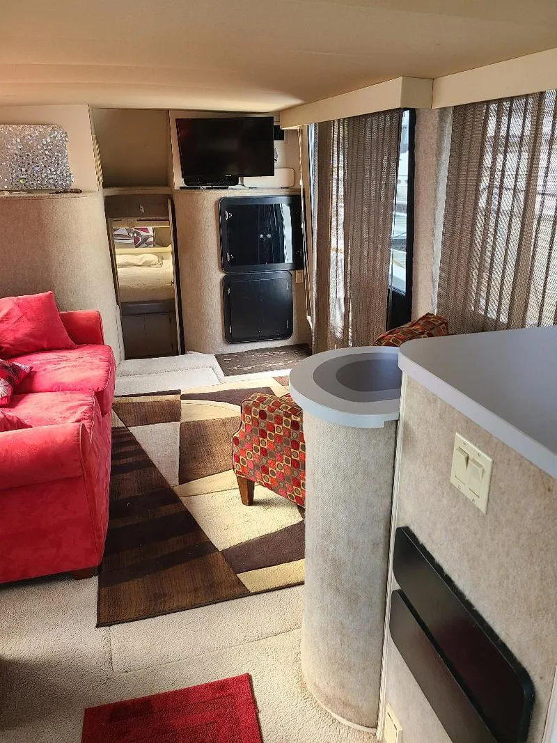 Slide: The Image of Interior of 1989 Bluewater Yachts Coastal Cruiser 42 with red sofa, TV, and modern decor. - 14