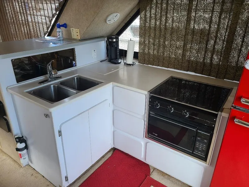 Slide: The Image of Compact kitchen in 1989 Bluewater Yachts Coastal Cruiser 42, featuring sink, stove, and red refrigerator. - 17