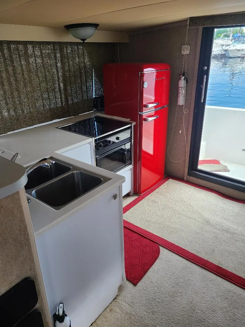 Slide: The Image of Interior of 1989 Bluewater Yachts Coastal Cruiser 42 with red retro fridge and kitchenette. - 19