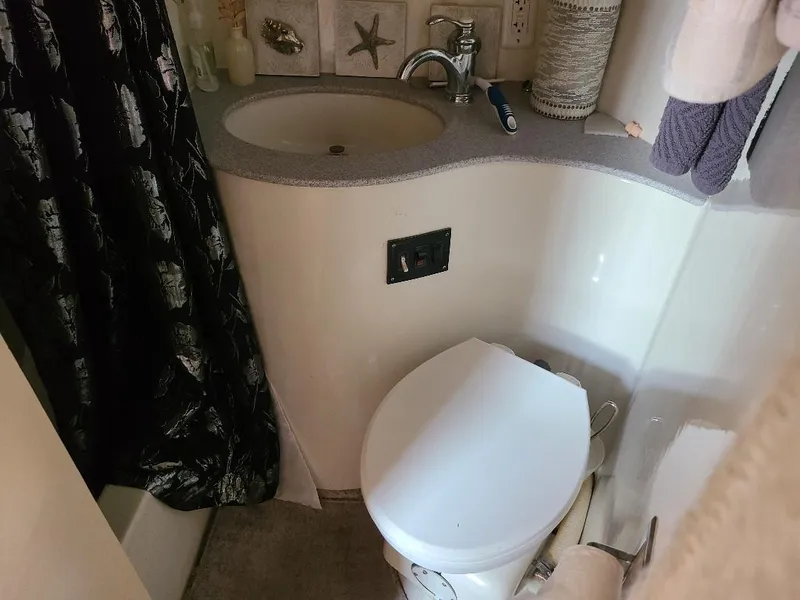 Slide: The Image of Compact bathroom in 1989 Bluewater Yachts Coastal Cruiser 42, featuring sink and toilet. - 24