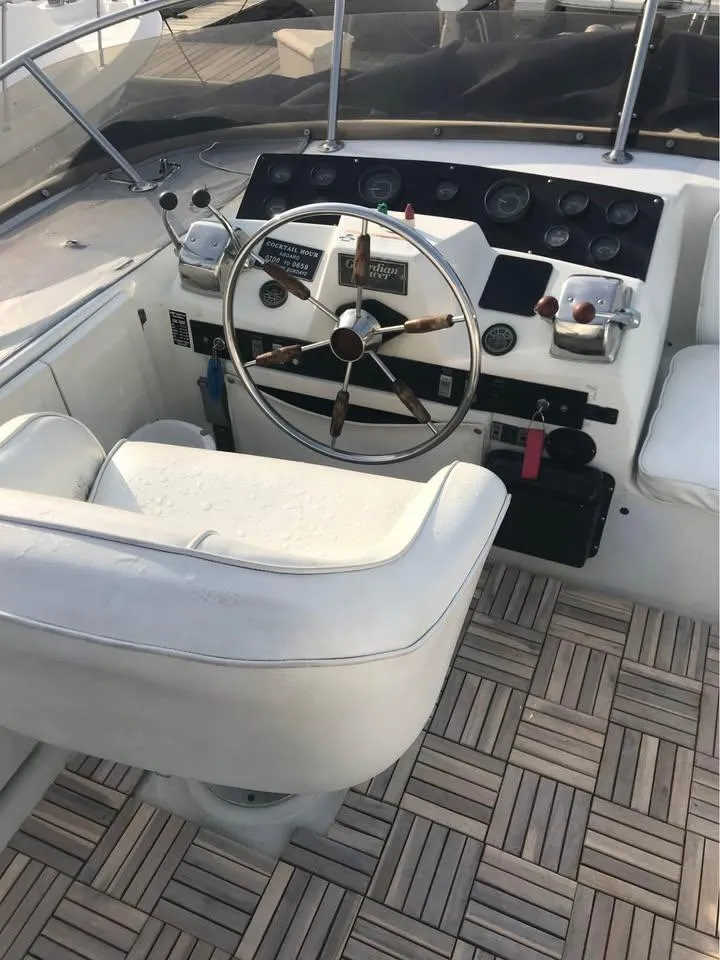 Slide: The Image of 1989 Bluewater Yachts Coastal Cruiser 42 helm with white seating and wooden deck. - 5