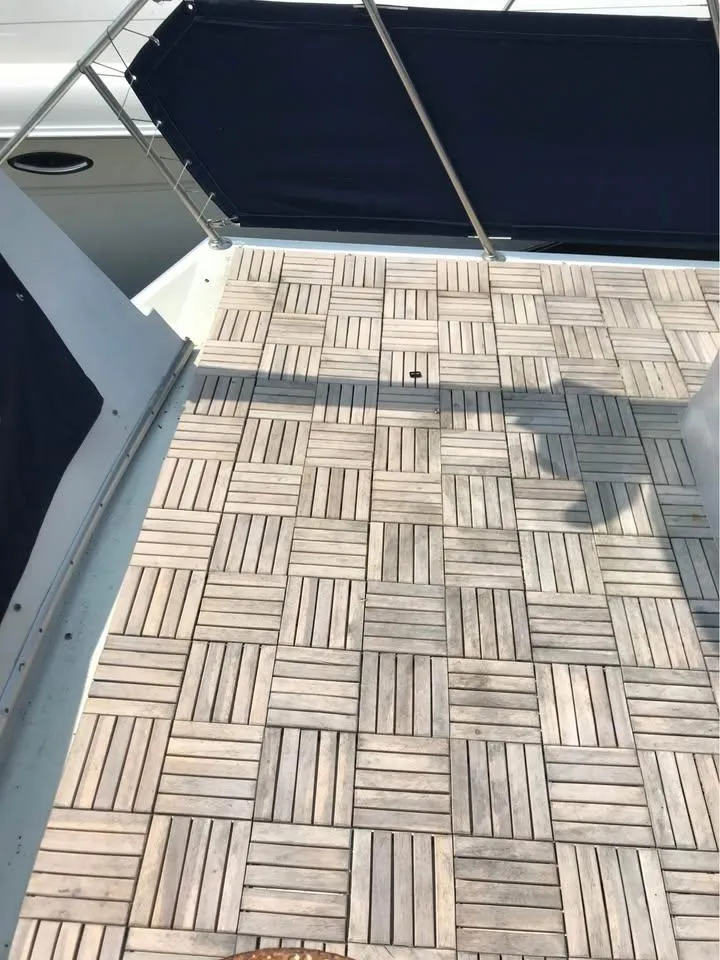 Slide: The Image of 1989 Bluewater Yachts Coastal Cruiser 42 deck with wooden flooring and blue rail covers. - 7
