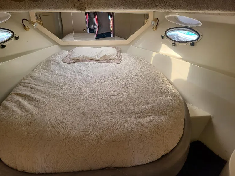 Slide: The Image of Cozy bedroom interior of 1989 Bluewater Yachts Coastal Cruiser 42 with round bed and portholes. - 9