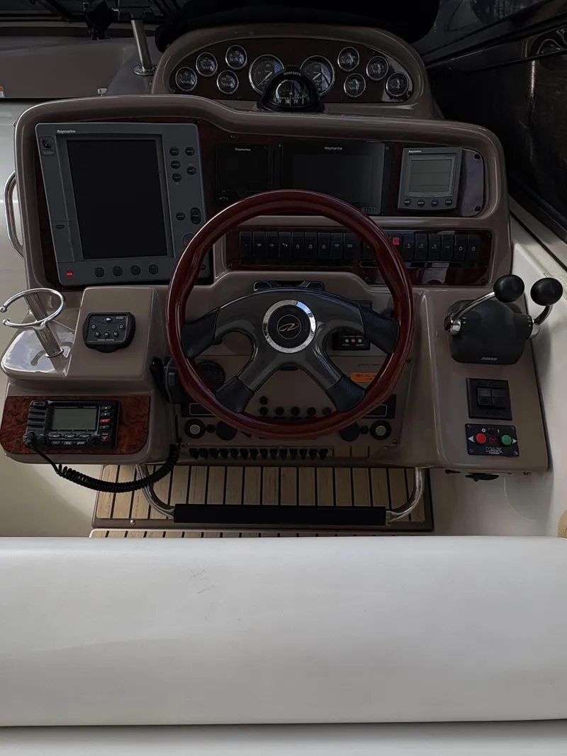 Slide: The Image of 2003 Regal 4260 Express Cruiser helm with steering wheel, navigation screens, and controls. - 14